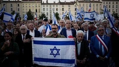 People hold and wave Israeli flags as they gather gather during a demonstration in a show of support for Israel, Tuesday in Lyon, central France. (AP)