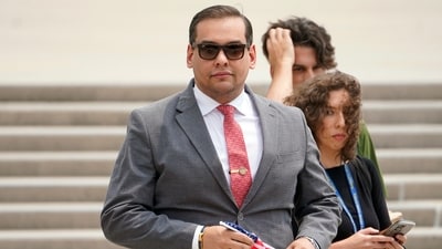 FILE - U.S. Rep. George Santos, R-N.Y., holds a miniature American flag that was presented to him as he departs federal court, June 30, 2023, in Central Islip, N.Y. (AP Photo/John Minchillo, File) (AP) FILE - U.S. Rep. George Santos, R-N.Y., holds a miniature American flag that was presented to him as he departs federal court, June 30, 2023, in Central Islip, N.Y. (AP Photo/John Minchillo, File) (AP)