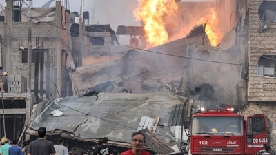 People watch as a firetruck is deployed outside a burning collapsed building following Israeli bombardment in Gaza City on October 11 (Photo by MOHAMMED ABED / AFP) (AFP) People watch as a firetruck is deployed outside a burning collapsed building following Israeli bombardment in Gaza City on October 11 (Photo by MOHAMMED ABED / AFP) (AFP)