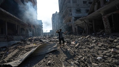 A Palestinian walks through the destruction due to Israeli strikes on Gaza. (AP)