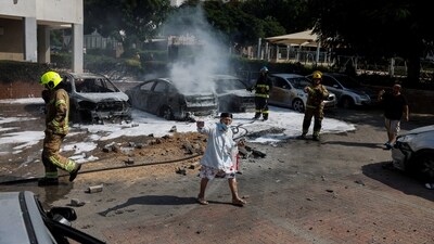 Israeli firefighters work to put out vehicles on fire after a rocket, launched from the Gaza Strip, landed in Ashkelon, southern Israel on Wednesday. (Reuters)