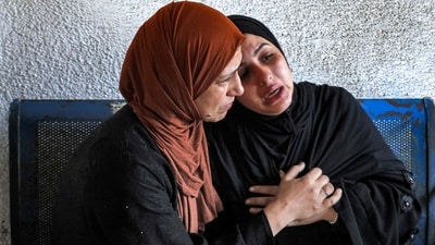 A woman comforts another outside the morgue of Al-Shifa Hospital in Gaza City. Doctors and nurses at the Al-Shifa hospital were busy treating hundreds of casualties from Israeli air raids as the Palestinian health ministry warned of a “catastrophic situation,” reported AFP. (Mohammed Abed / AFP) A woman comforts another outside the morgue of Al-Shifa Hospital in Gaza City. Doctors and nurses at the Al-Shifa hospital were busy treating hundreds of casualties from Israeli air raids as the Palestinian health ministry warned of a “catastrophic situation,” reported AFP. (Mohammed Abed / AFP)