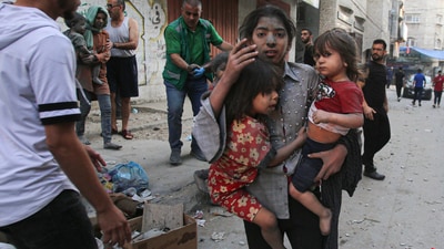 A Palestinian girl holds two children on a street in Gaza City. According to a Reuters report, the Gazan health authorities have said more than 1,400 people have been killed and over 6,000 have been wounded in the bombing. The sole electric power station has been switched off and hospitals are running out of fuel for emergency generators. (Bashar Taleb / AFP) A Palestinian girl holds two children on a street in Gaza City. According to a Reuters report, the Gazan health authorities have said more than 1,400 people have been killed and over 6,000 have been wounded in the bombing. The sole electric power station has been switched off and hospitals are running out of fuel for emergency generators. (Bashar Taleb / AFP)