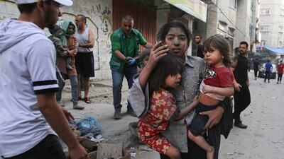 A Palestinian girl holds two children on a street in Gaza City. According to a Reuters report, the Gazan health authorities have said more than 1,400 people have been killed and over 6,000 have been wounded in the bombing. The sole electric power station has been switched off and hospitals are running out of fuel for emergency generators. (Bashar Taleb / AFP) A Palestinian girl holds two children on a street in Gaza City. According to a Reuters report, the Gazan health authorities have said more than 1,400 people have been killed and over 6,000 have been wounded in the bombing. The sole electric power station has been switched off and hospitals are running out of fuel for emergency generators. (Bashar Taleb / AFP)