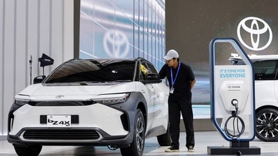 A worker cleans Toyota's Electric Vehicle bZ4X, that is displayed during the Gaikindo Indonesia International Auto Show in Tangerang, near Jakarta, Indonesia. (REUTERS)