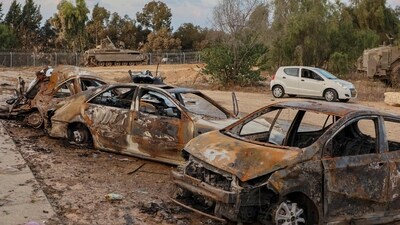 A rescuer walks past destroyed cars at scene of an attack in the Israeli kibbutz of Kfar Aza on the border with the Gaza Strip on October 11, 2023 (Photo by GIL COHEN-MAGEN / AFP) (AFP) A rescuer walks past destroyed cars at scene of an attack in the Israeli kibbutz of Kfar Aza on the border with the Gaza Strip on October 11, 2023 (Photo by GIL COHEN-MAGEN / AFP) (AFP)