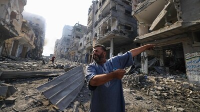 A Palestinian man points at destruction as people inspect the damage following overnight Israeli airstrikes in the Gaza Strip's Jabalia refugee camp on October 11, 2023. (AFP) A Palestinian man points at destruction as people inspect the damage following overnight Israeli airstrikes in the Gaza Strip's Jabalia refugee camp on October 11, 2023. (AFP)