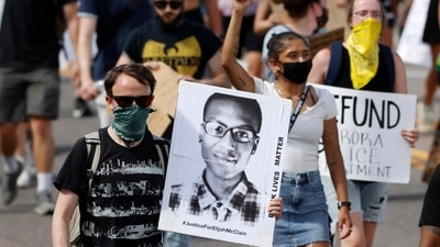 A demonstrator carries an image of Elijah McClain during a rally and march, June 27, 2020, in Colorado. (AP)