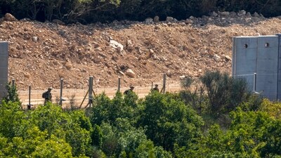 Israeli soldiers add new fence alongside the border wall with Lebanon as seen from the Lebanese side of the Lebanese-Israeli border (AP)