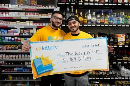 Jonathan Khalil, left, and Chris Khalil, sons of the store co-owners, hold up a ceremonial check presented to them by lottery officials at the Midway Market & Liquor store, Thursday, Oct. 12, 2023, in Frazier Park, Calif., where a $1.765 billion winning Powerball ticket was sold. (AP Photo/Marcio Jose Sanchez) (AP) Jonathan Khalil, left, and Chris Khalil, sons of the store co-owners, hold up a ceremonial check presented to them by lottery officials at the Midway Market & Liquor store, Thursday, Oct. 12, 2023, in Frazier Park, Calif., where a $1.765 billion winning Powerball ticket was sold. (AP Photo/Marcio Jose Sanchez) (AP)