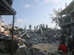 Israel-Hamas War: Palestinians stand by the building destroyed in an Israeli airstrike in Rafah, Gaza Strip. Israel-Hamas War: Palestinians stand by the building destroyed in an Israeli airstrike in Rafah, Gaza Strip.