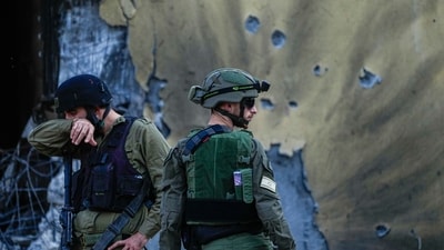 Israel-Hamas War: Israeli soldiers walk past houses destroyed by Hamas militants in Kibbutz Be'eri, Israel. (AP) Israel-Hamas War: Israeli soldiers walk past houses destroyed by Hamas militants in Kibbutz Be'eri, Israel. (AP)