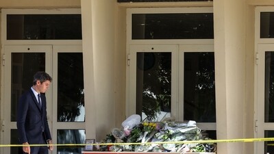 France School Stabbing: French Education and Youth Minister Gabriel Attal (L) stands in attention before flowers laid in front of the Gambetta high school in Arras. (AFP) France School Stabbing: French Education and Youth Minister Gabriel Attal (L) stands in attention before flowers laid in front of the Gambetta high school in Arras. (AFP)