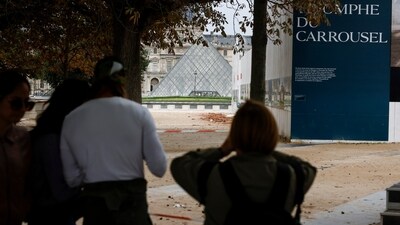 People wait outside the Louvre Museum as the place is evacuated after it received a written threat, in Paris. (AP)