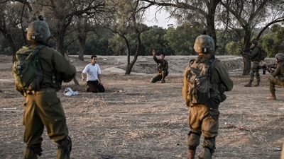 Israeli soldiers detain a man while on patrol near Kibbutz Beeri, the place where 270 revellers were killed by Hamas militants during the Supernova music festival on October 7. (AFP) Israeli soldiers detain a man while on patrol near Kibbutz Beeri, the place where 270 revellers were killed by Hamas militants during the Supernova music festival on October 7. (AFP)