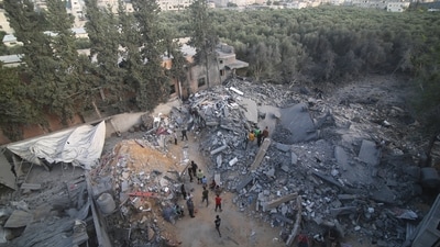 Palestinians stand by the building destroyed in an Israeli airstrike in Rafah, Gaza Strip, (AP) Palestinians stand by the building destroyed in an Israeli airstrike in Rafah, Gaza Strip, (AP)