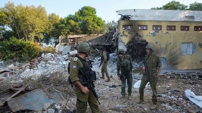 Israel-Hamas War: Israeli soldiers walk past houses destroyed by Hamas militants in Kibbutz Be'eri, Israel. (AP) Israel-Hamas War: Israeli soldiers walk past houses destroyed by Hamas militants in Kibbutz Be'eri, Israel. (AP)