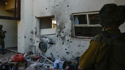 Israel-Hamas War: Israeli soldiers walk past a house damaged by Hamas militants in Kibbutz Be'eri, Israel. (AP) Israel-Hamas War: Israeli soldiers walk past a house damaged by Hamas militants in Kibbutz Be'eri, Israel. (AP)