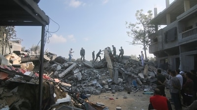 Israel-Hamas War: Palestinians stand by the building destroyed in an Israeli airstrike in Rafah, Gaza Strip. (AP) Israel-Hamas War: Palestinians stand by the building destroyed in an Israeli airstrike in Rafah, Gaza Strip. (AP)