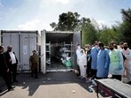Israeli forensic members and soldiers gather next a container where the bodies of Israeli casualties are being stored at the army base in Ramla, on October 13, 2023. Israeli forensic members and soldiers gather next a container where the bodies of Israeli casualties are being stored at the army base in Ramla, on October 13, 2023.