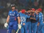 England's captain Jos Butler leaves the ground after losing his wicket as Afghanistan's Naveen-ul-Haq celebrates with teammates during the ICC Men's Cricket World Cup match between Afghanistan and England England's captain Jos Butler leaves the ground after losing his wicket as Afghanistan's Naveen-ul-Haq celebrates with teammates during the ICC Men's Cricket World Cup match between Afghanistan and England