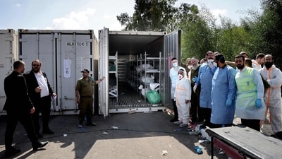 Israeli forensic members and soldiers gather next a container where the bodies of Israeli casualties are being stored at the army base in Ramla, on October 13, 2023. (AFP) Israeli forensic members and soldiers gather next a container where the bodies of Israeli casualties are being stored at the army base in Ramla, on October 13, 2023. (AFP)