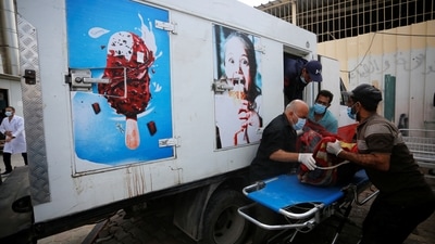 People move the body of a Palestinian, who was killed in Israeli strikes, from an ice cream truck where it was kept, as the hospital morgues are packed (REUTERS)