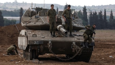 Israeli soldiers stand atop an Israeli tank near Israel's border with the Gaza Strip. (REUTERS)