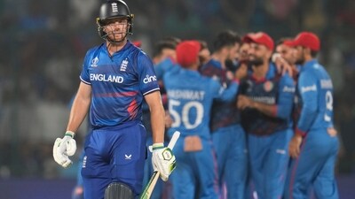 England's captain Jos Butler leaves the ground after losing his wicket as Afghanistan's Naveen-ul-Haq celebrates with teammates during the ICC Men's Cricket World Cup match between Afghanistan and England (AP) England's captain Jos Butler leaves the ground after losing his wicket as Afghanistan's Naveen-ul-Haq celebrates with teammates during the ICC Men's Cricket World Cup match between Afghanistan and England (AP)