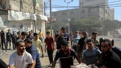 Israel-Hamas War: Palestinians carry the body of a man following Israeli airstrikes hitting buildings, in Gaza City central of the Gaza Strip. (AP) Israel-Hamas War: Palestinians carry the body of a man following Israeli airstrikes hitting buildings, in Gaza City central of the Gaza Strip. (AP)