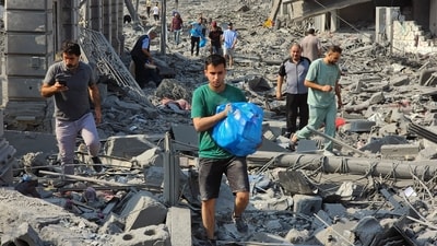 Palestinians walk through the rubble of buildings destroyed by Israeli airstrikes in Gaza City October 10. (AP) Palestinians walk through the rubble of buildings destroyed by Israeli airstrikes in Gaza City October 10. (AP)