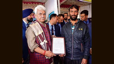 L-G Manoj Sinha hands over land allotment letter to a beneficiary of Pradhan Mantri Awaas Yojana in Bandipora on Sunday (HT Photo) L-G Manoj Sinha hands over land allotment letter to a beneficiary of Pradhan Mantri Awaas Yojana in Bandipora on Sunday (HT Photo)