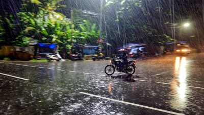 A motorcyclist caught in rain, in Thiruvananthapuram. (PTI)