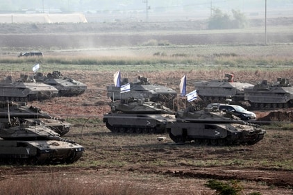 Israeli troops in tanks and other armoured vehicles amass in a field near the southern Israeli city of Ashkelon. (AFP)