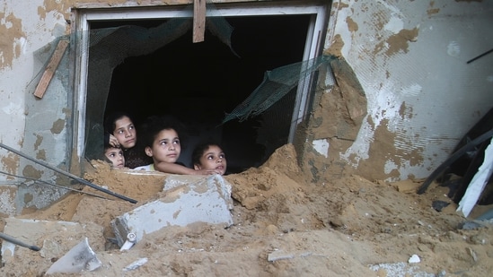 Palestinian children look at the building of the Zanon family, destroyed in Israeli airstrikes in Rafah, Gaza Strip, (AP)