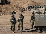 Israeli soldiers stand near their armoured vehicles stationed close to the border with the Gaza Strip on October 15. Israeli soldiers stand near their armoured vehicles stationed close to the border with the Gaza Strip on October 15.