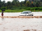 Commuters move through the waterlogged road following heavy rain, in Thiruvananthapuram. 