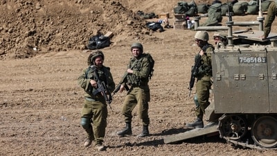Israeli soldiers stand near their armoured vehicles stationed close to the border with the Gaza Strip on October 15. (AFP)