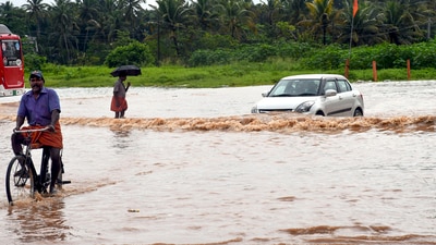 Commuters move through the waterlogged road following heavy rain, in Thiruvananthapuram. (PTI) Commuters move through the waterlogged road following heavy rain, in Thiruvananthapuram. (PTI)