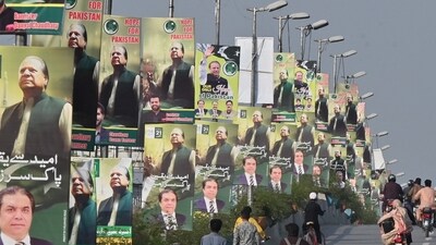Commuters ride past the welcoming posters of former Pakistan's Prime Minister Nawaz Sharif. (AFP) Commuters ride past the welcoming posters of former Pakistan's Prime Minister Nawaz Sharif. (AFP)