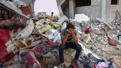 A Palestinian youth sits on the rubble of a destroyed home following an Israeli military strike on the Rafah refugee camp in southern Gaza Strip on October 15. (AFP)