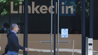 A pedestrian walks by a sign at a LinkedIn office (Getty Images via AFP)