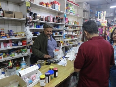Mr Anil Prakash, proprietor Prakash Stores, can be seen taking orders from customers. (HT/Avinash Singh Sudan)