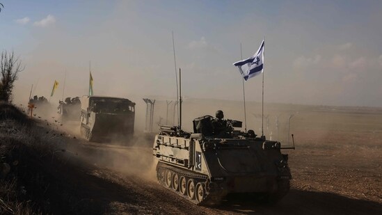 A convoy of Israeli military vehicles drives down a road at an undisclosed location on the border with the Gaza Strip (AFP)