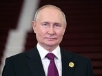 Russian president Vladimir Putin looks on.