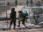 Israeli soldiers patrol a border fence gate with the Gaza Strip on October 15. Israeli soldiers patrol a border fence gate with the Gaza Strip on October 15.