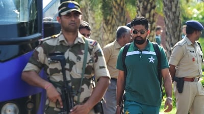 Pakistan's captain, Babar Azam (C) walks to board Pakistan's team bus amid security personnel upon landing at the airport in Ahmedabad (AFP)