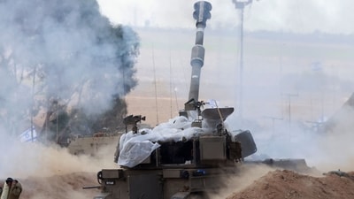 Israel-Hamas War: Israeli soldiers block their ears as a M109 155mm self-propelled howitzer fires rounds from near the Israeli border with Gaza. (AFP) Israel-Hamas War: Israeli soldiers block their ears as a M109 155mm self-propelled howitzer fires rounds from near the Israeli border with Gaza. (AFP)