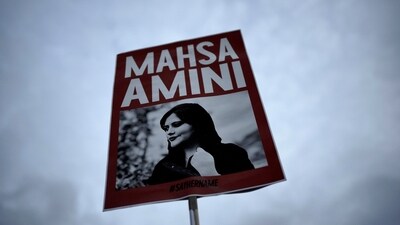 Iran Anti-Hijab Protests: A woman holds a placard with a picture of Iranian woman Mahsa Amini during a protest against her death. (AP) Iran Anti-Hijab Protests: A woman holds a placard with a picture of Iranian woman Mahsa Amini during a protest against her death. (AP)