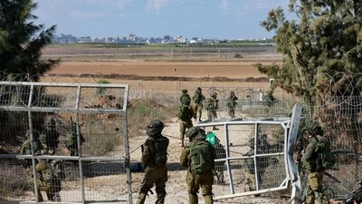Israeli troops patrol at a gate leading to kibbutz Kfar Aza on the border with the Gaza Strip on October 15, 2023, where at least 100 people were reported killed by Hamas (Photo by Menahem KAHANA / AFP) (AFP) Israeli troops patrol at a gate leading to kibbutz Kfar Aza on the border with the Gaza Strip on October 15, 2023, where at least 100 people were reported killed by Hamas (Photo by Menahem KAHANA / AFP) (AFP)